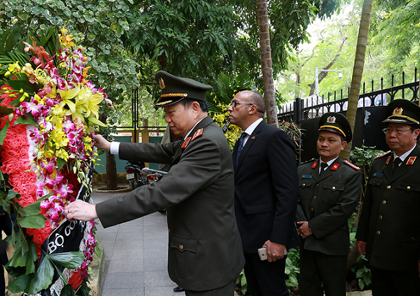 Bộ trưởng Tô Lâm chỉnh sửa lại vòng hoa trước khi thực hiện nghi lễ.